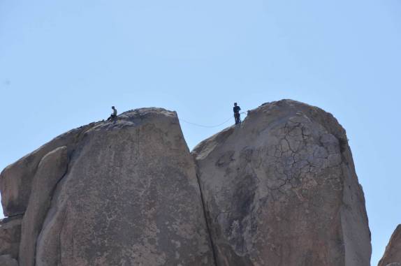 Para onde se olhe, há grandes paredões de pedra e pessoas escalando, no Joshua Tree National Park, região de Pioneertown, na Califórnia - Estados Unidos